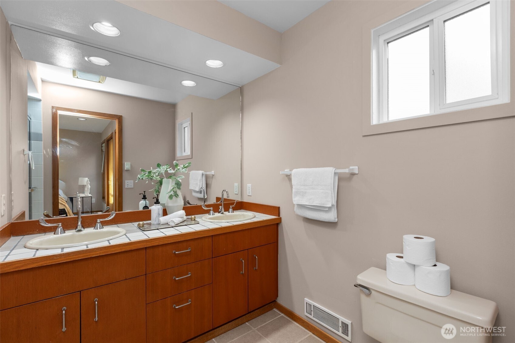 3200 Alki Avenue Southwest, Unit 301 Seattle, WA 98116 - Photo 16 of 29 a bathroom with a double vanity sink and mirror