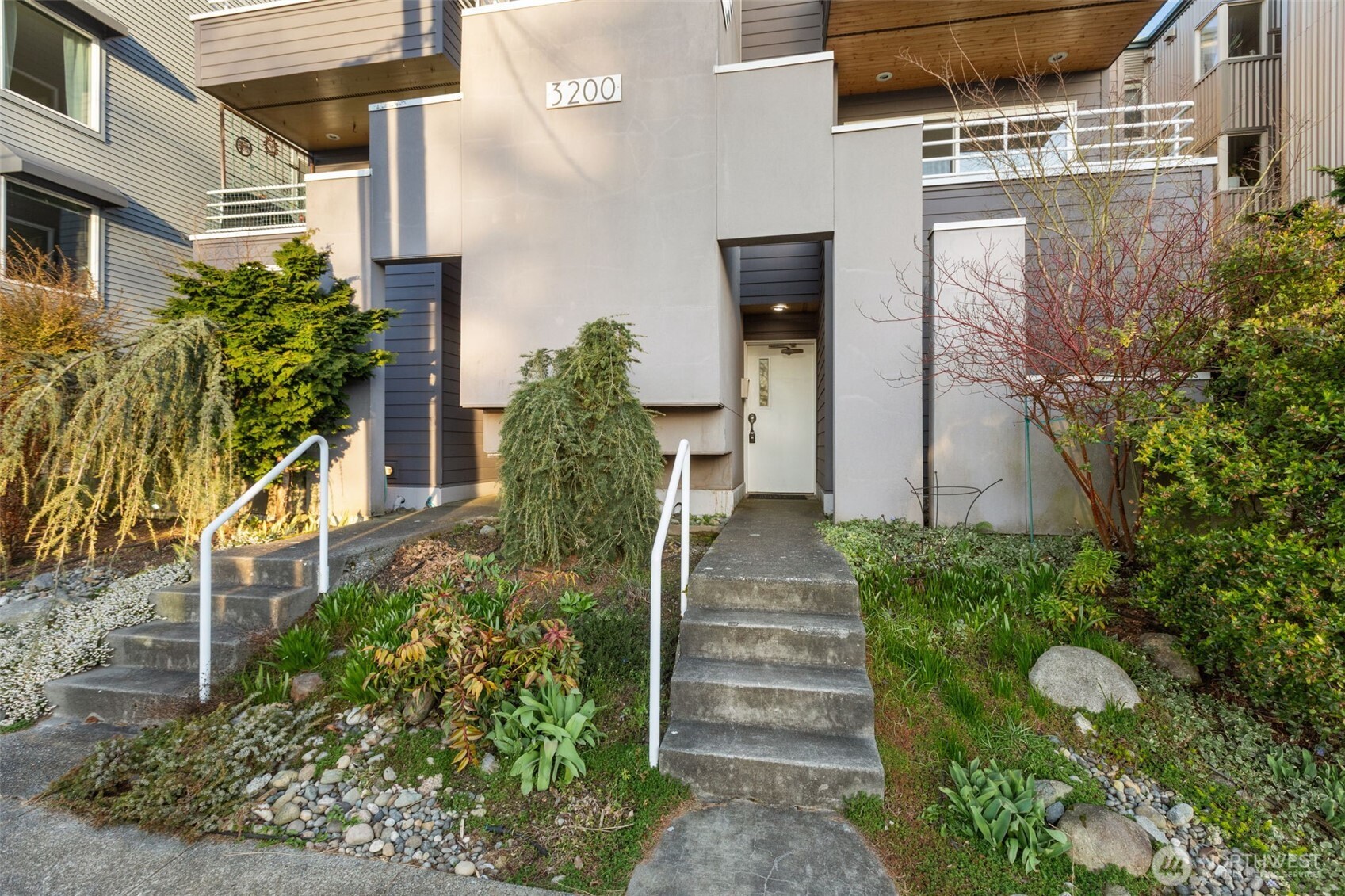 3200 Alki Avenue Southwest, Unit 301 Seattle, WA 98116 - Photo 27 of 29 a front view of a house with a yard and garden