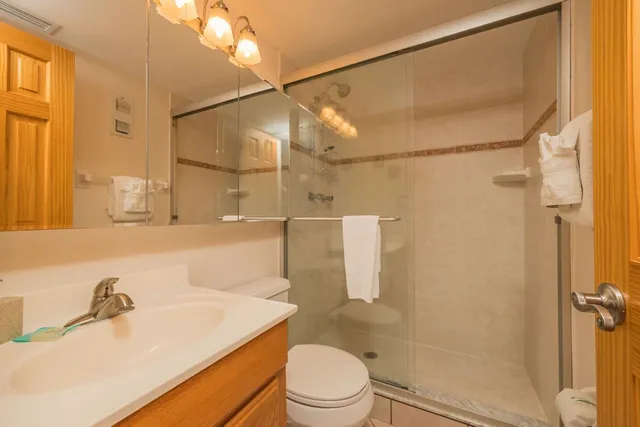 a bathroom with a sink vanity mirror and toilet