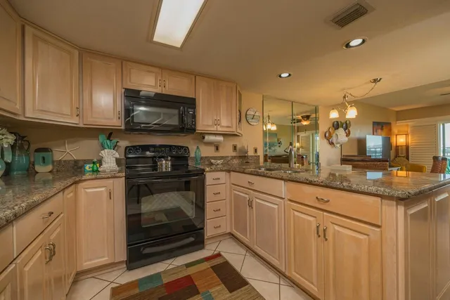 a kitchen with stainless steel appliances granite countertop a stove a sink and a microwave
