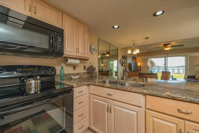 a kitchen with stainless steel appliances granite countertop a sink stove and microwave