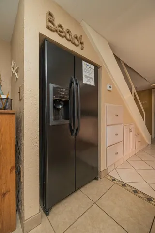 a view of a refrigerator in kitchen and an empty room