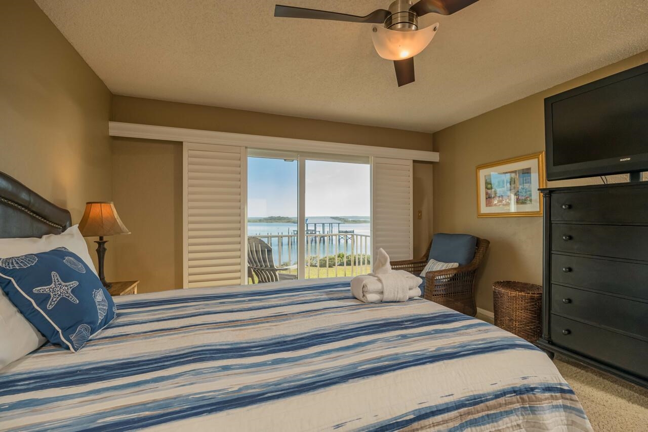 7265 A1A South, Unit B3 St. Augustine, FL 32080 - Photo 20 of 45 a bedroom with a bed a large window and flat screen tv