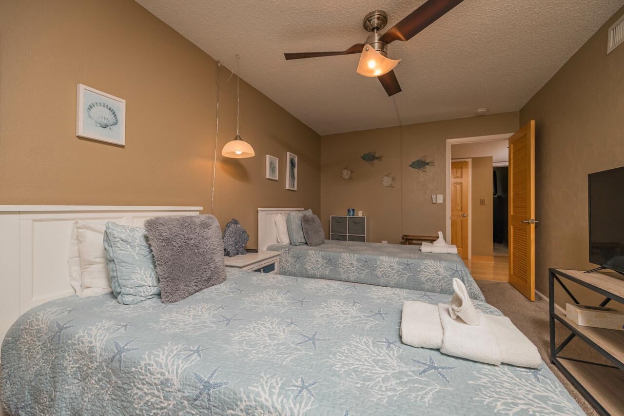 7265 A1A South, Unit B3 St. Augustine, FL 32080 - Photo 24 of 45 a bedroom with a large bed and a flat tv screen on dresser