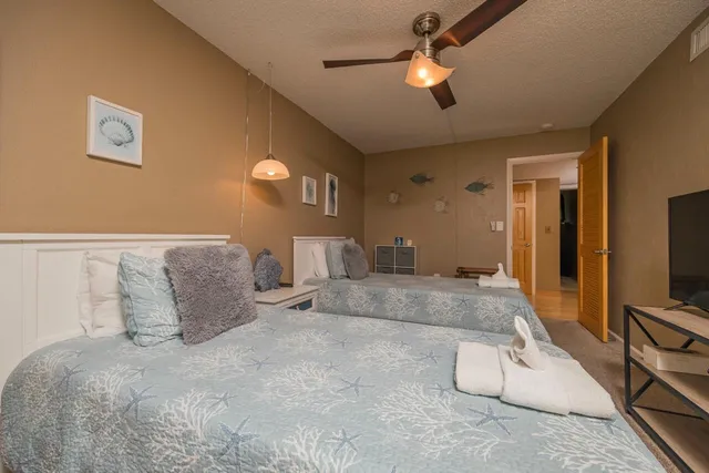 a bedroom with a large bed and a flat tv screen on dresser
