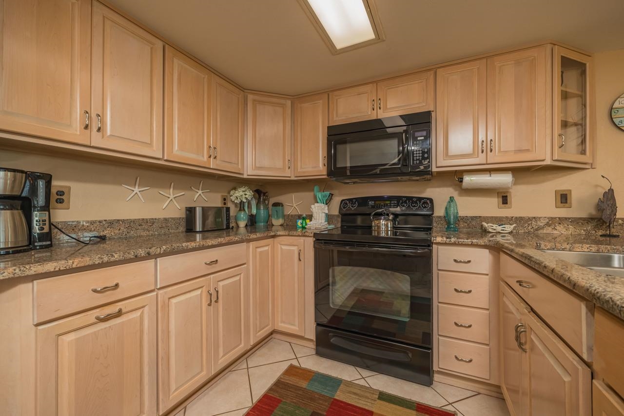 7265 A1A South, Unit B3 St. Augustine, FL 32080 - Photo 37 of 45 a kitchen with granite countertop white cabinets stainless steel appliances and sink