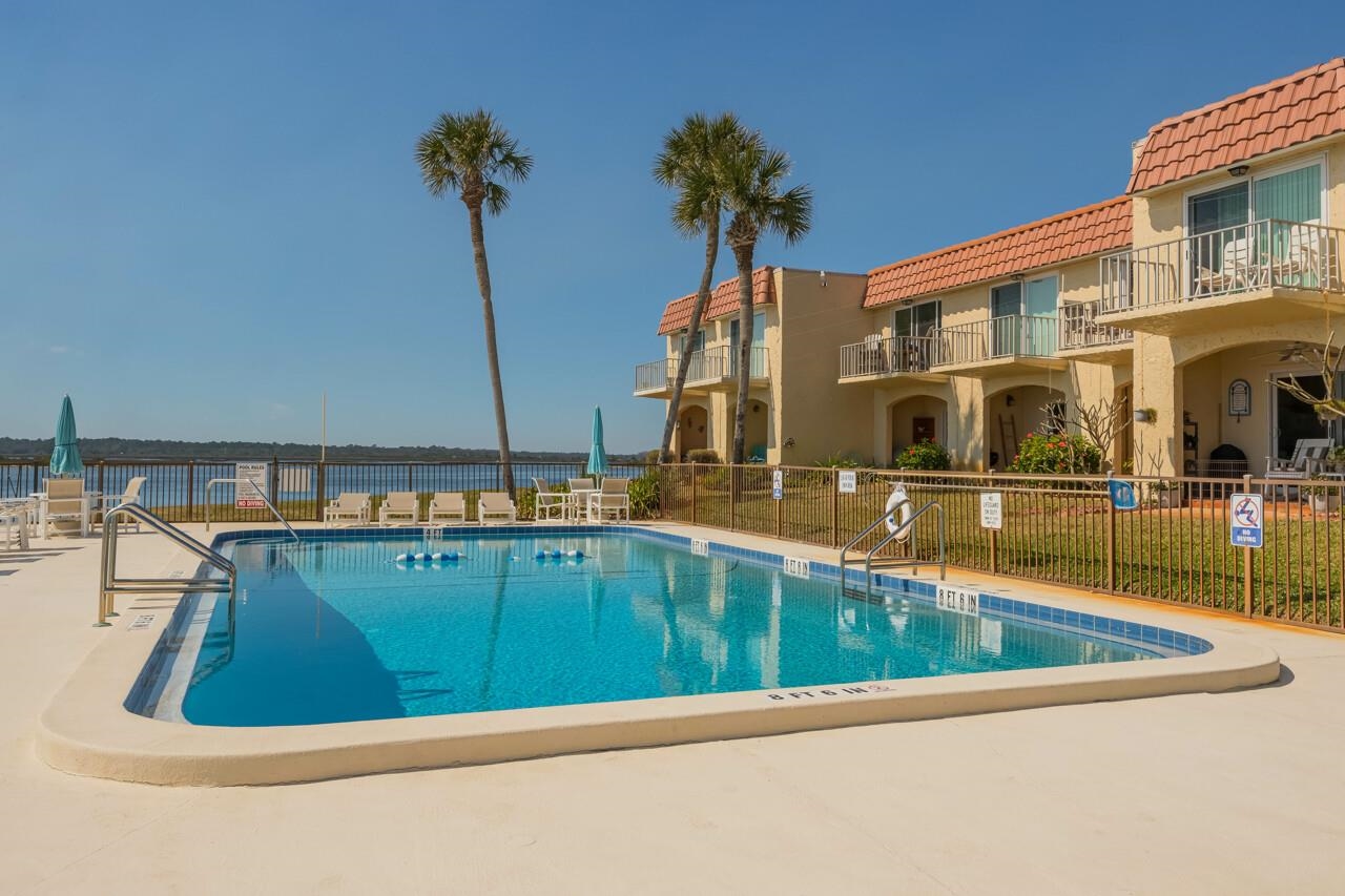 7265 A1A South, Unit B3 St. Augustine, FL 32080 - Photo 5 of 45 a view of swimming pool with a chair and palm trees