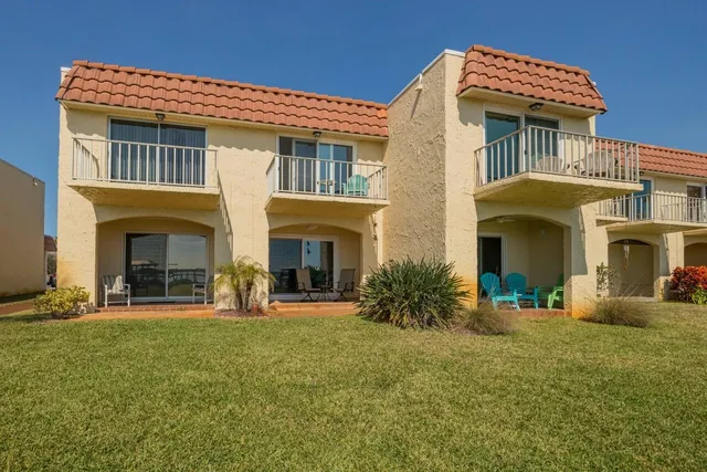 a front view of a house with yard and outdoor seating