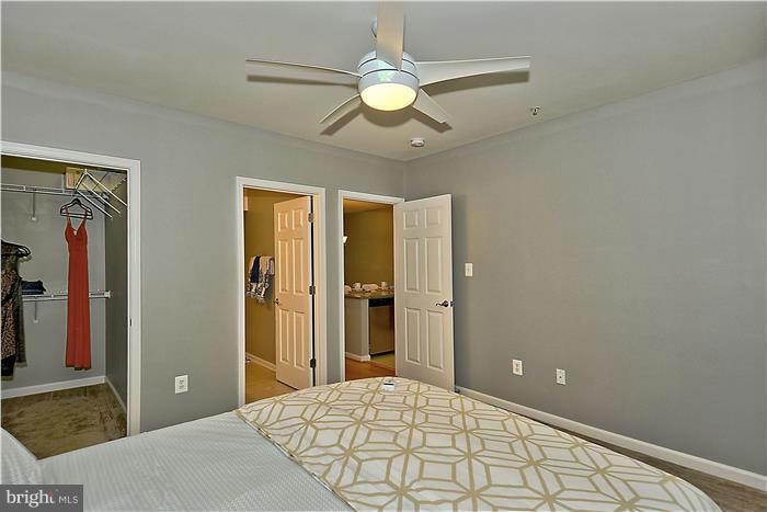 11349 King George Drive, Unit 10 Silver Spring, MD 20902 - Photo 12 of 20 a bedroom with a large bed and a chandelier