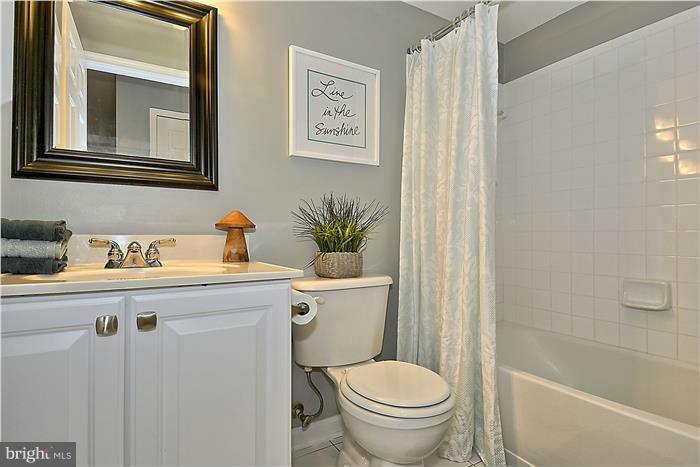11349 King George Drive, Unit 10 Silver Spring, MD 20902 - Photo 17 of 20 a bathroom with a granite countertop toilet sink and mirror