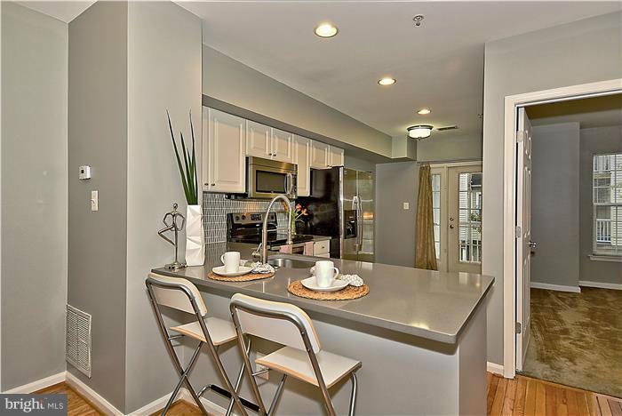 11349 King George Drive, Unit 10 Silver Spring, MD 20902 - Photo 8 of 20 a kitchen with stainless steel appliances kitchen island granite countertop a sink and cabinets