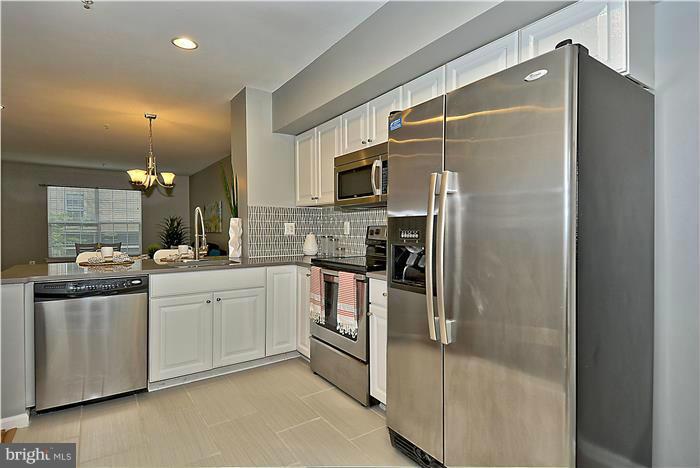 11349 King George Drive, Unit 10 Silver Spring, MD 20902 - Photo 10 of 20 a kitchen with stainless steel appliances granite countertop a refrigerator and a stove top oven