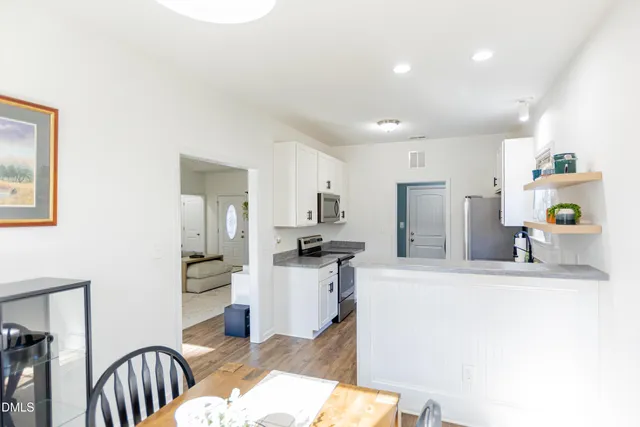 a kitchen with stainless steel appliances kitchen island granite countertop a refrigerator and a sink