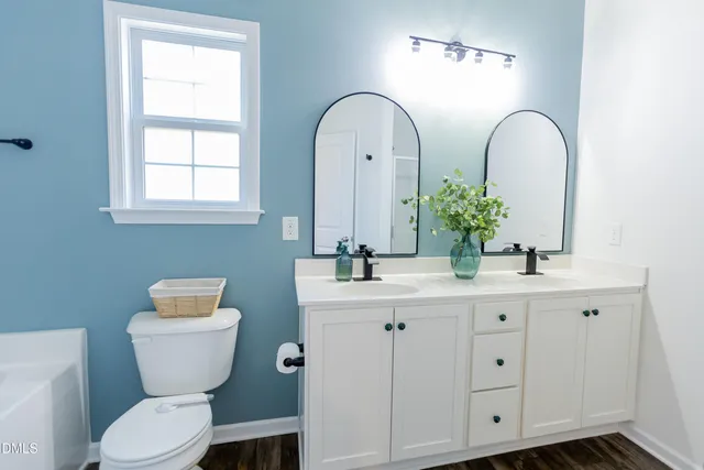 a bathroom with a toilet sink and mirror