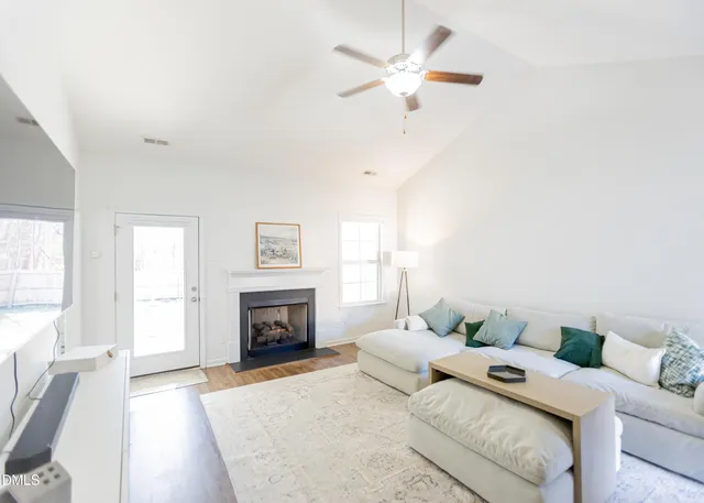 a living room with furniture fireplace and a window