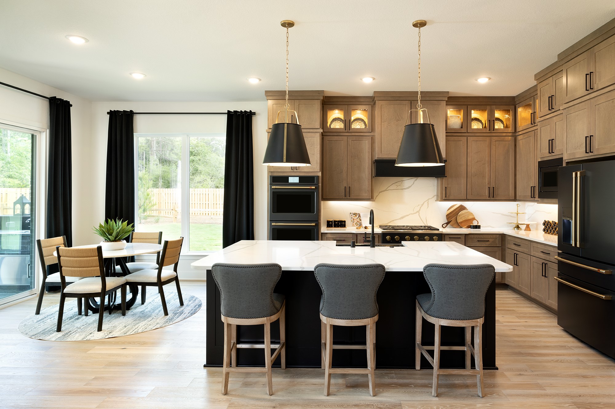 41885 Wendele Way Montgomery, TX 77316 - Photo 3 of 27 a kitchen with stainless steel appliances kitchen island granite countertop a dining table chairs and refrigerator