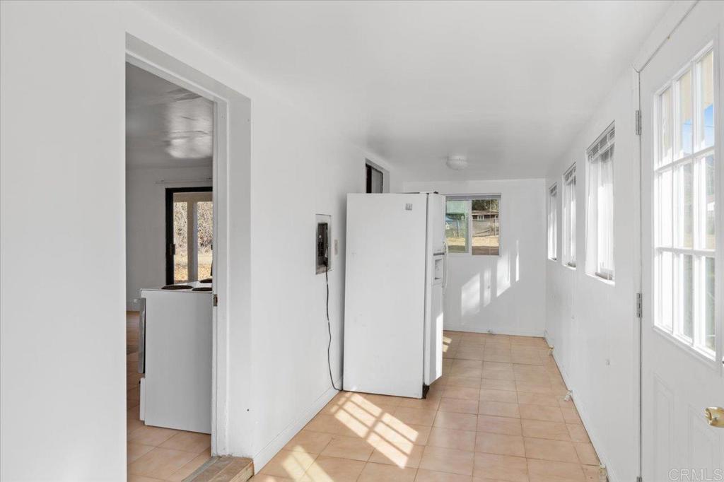 34174 Hampton Road Pauma Valley, CA 92061 - Photo 7 of 20 a view of a hallway with windows and refrigerator