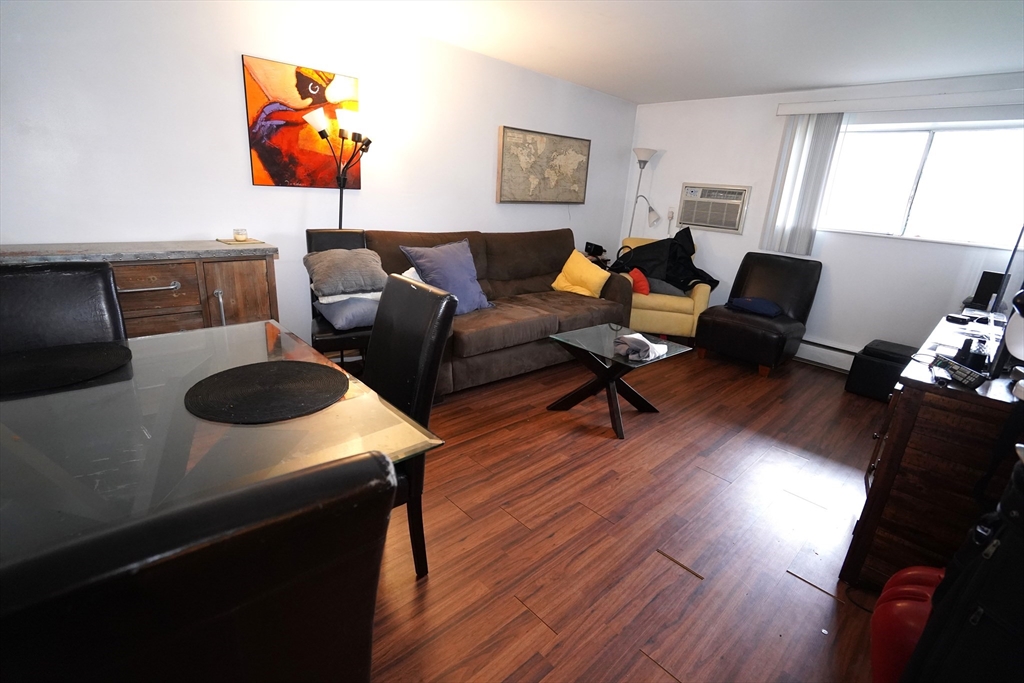 140 Kenrick Street, Unit 8 Boston, MA 02135 - Photo 1 of 16 a living room with furniture and a wooden floor