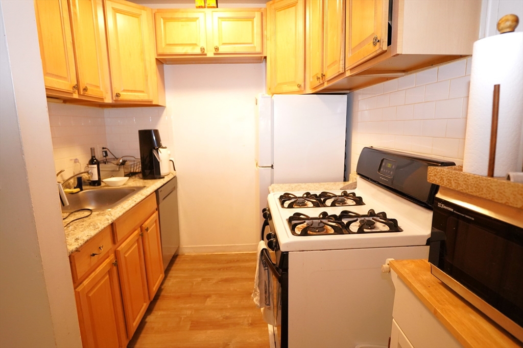 140 Kenrick Street, Unit 8 Boston, MA 02135 - Photo 5 of 16 a kitchen with a sink stove and refrigerator