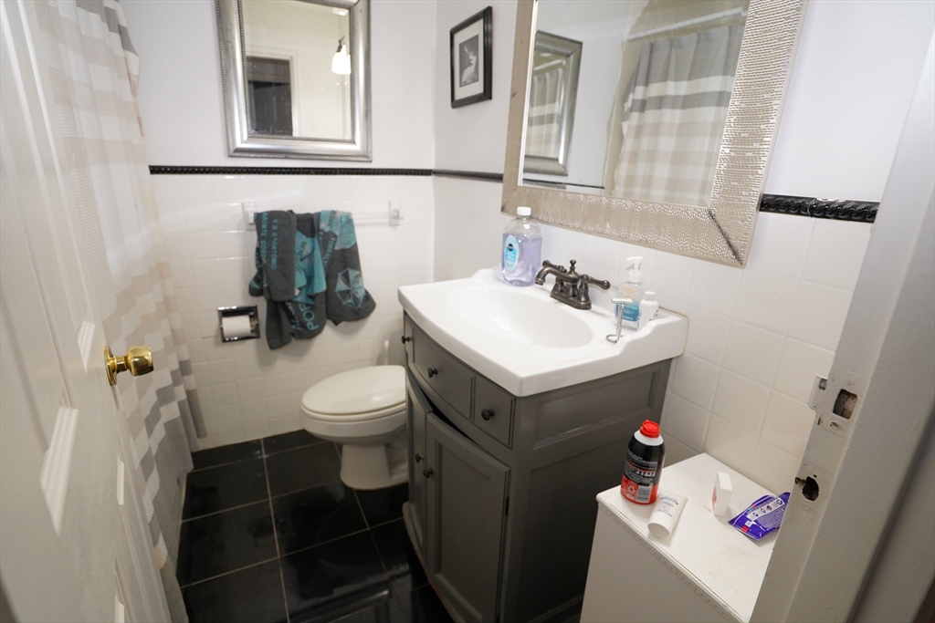 140 Kenrick Street, Unit 8 Boston, MA 02135 - Photo 6 of 16 a bathroom with a sink toilet and mirror
