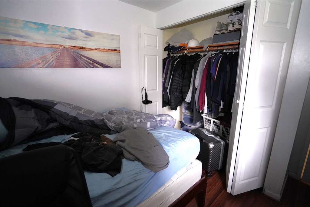 140 Kenrick Street, Unit 8 Boston, MA 02135 - Photo 9 of 16 a view of walk in closet with clothes and shoes