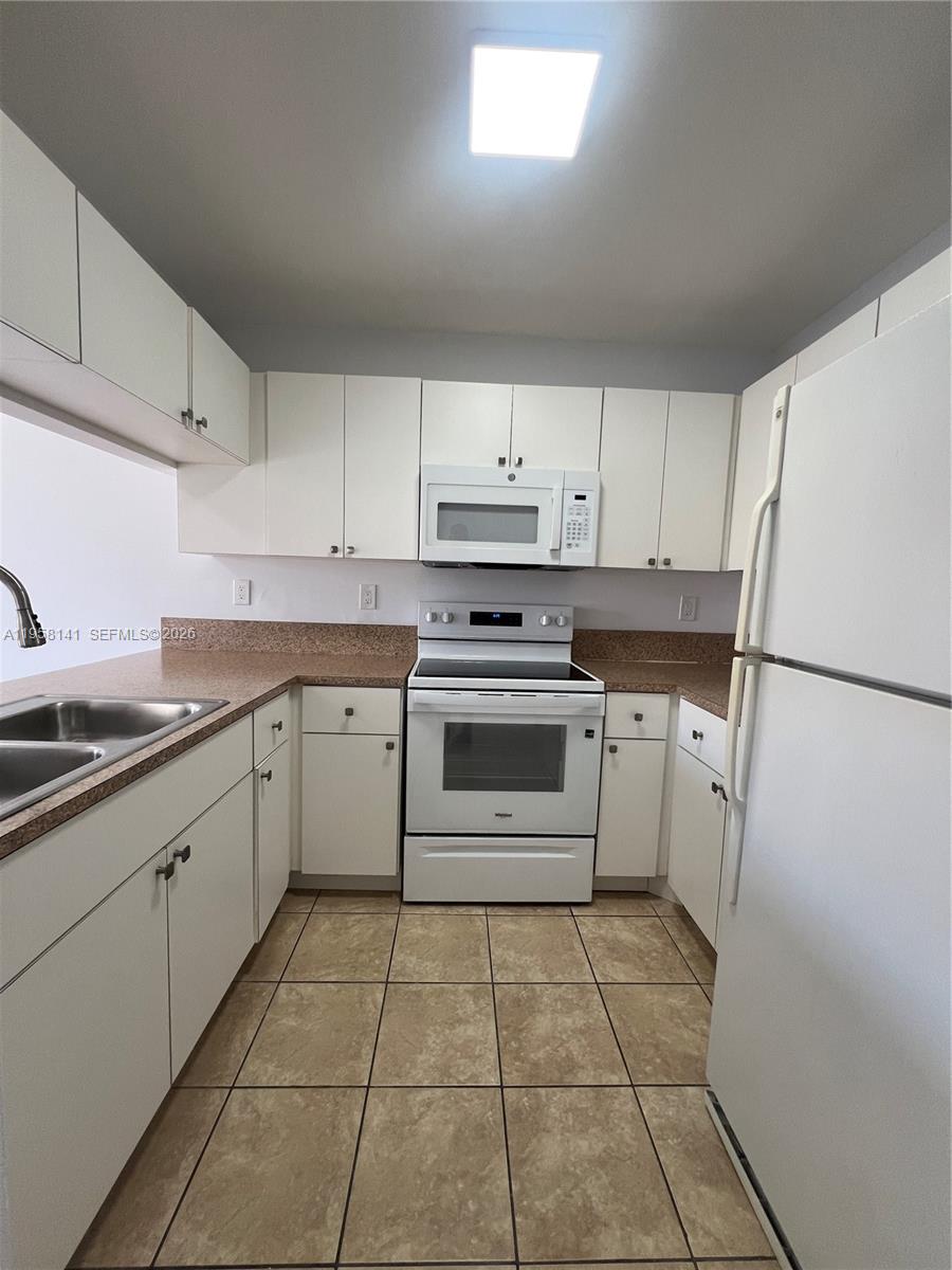 9720 Southwest 184th Street, Unit 210 Cutler Bay, FL 33157 - Photo 4 of 12 a kitchen with a stove sink and refrigerator