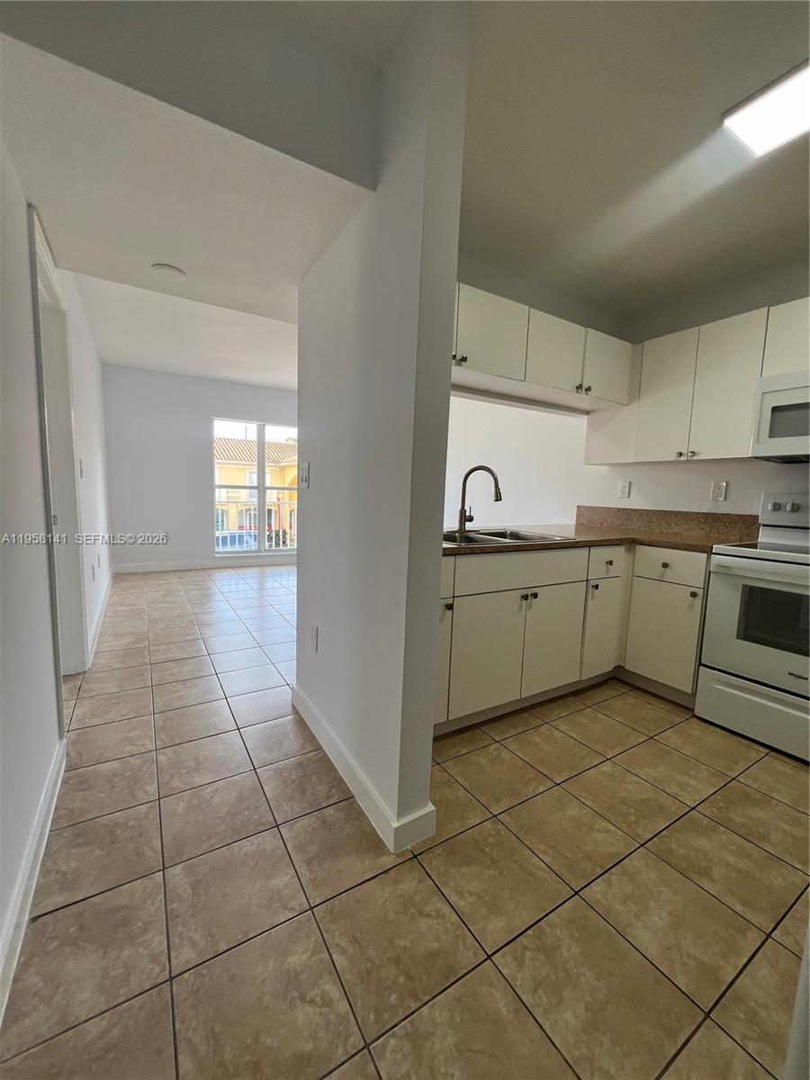 9720 Southwest 184th Street, Unit 210 Cutler Bay, FL 33157 - Photo 5 of 12 a kitchen with a sink a stove and cabinets