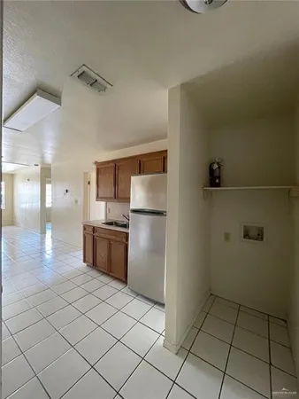 a kitchen with granite countertop a refrigerator and a stove top oven