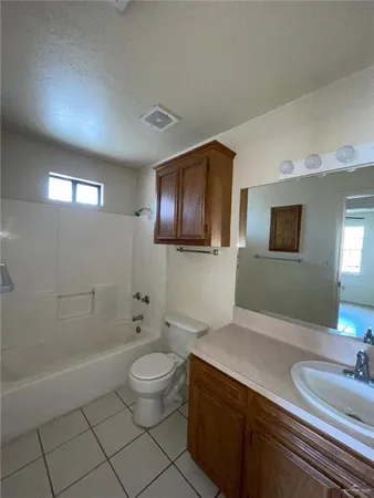 a spacious bathroom with a toilet sink and mirror