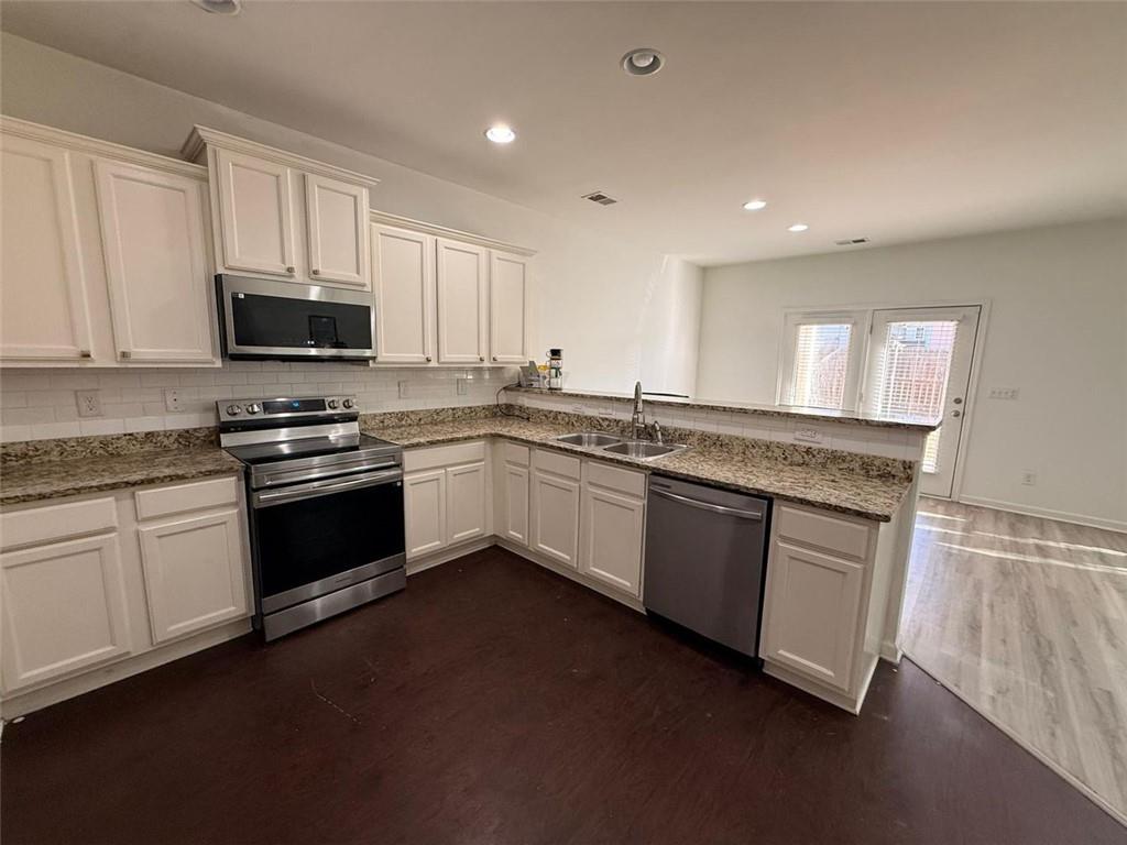 2450 Oakleaf Circle Lithonia, GA 30058 - Photo 14 of 40 a kitchen with stainless steel appliances granite countertop a stove a sink and a microwave