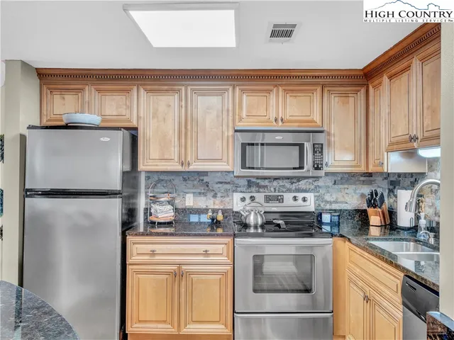 a kitchen with stainless steel appliances granite countertop a refrigerator sink and cabinets