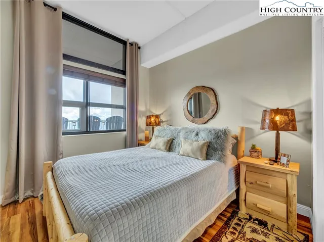 a bedroom with a bed and a dresser next to a window