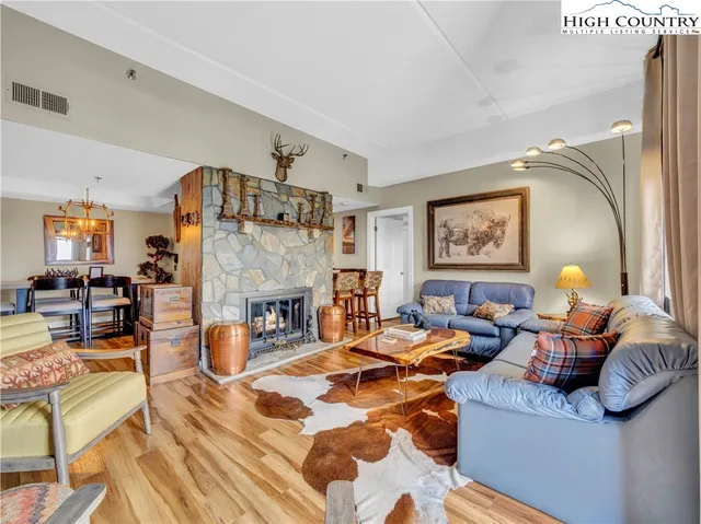 a living room with fireplace furniture and a rug