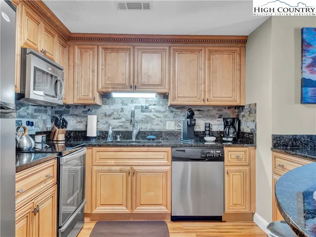 a kitchen with granite countertop wooden cabinets and a stove top oven