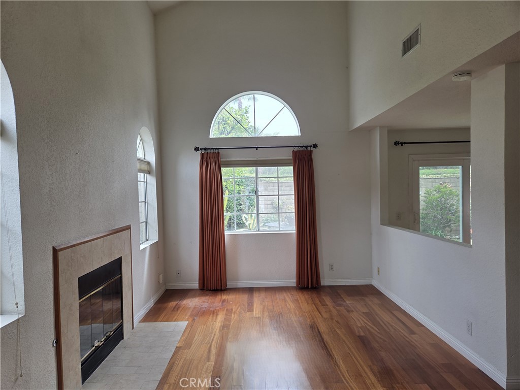 1330 Meadow Lane Duarte, CA 91010 - Photo 3 of 15 an empty room with windows fireplace and wooden floor