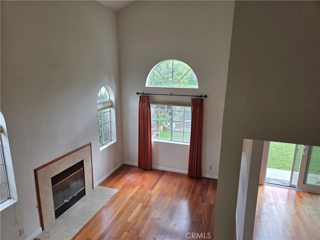 1330 Meadow Lane Duarte, CA 91010 - Photo 4 of 15 an empty room with wooden floor a fireplace and windows