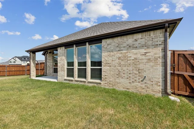 a view of a backyard with plants and large trees