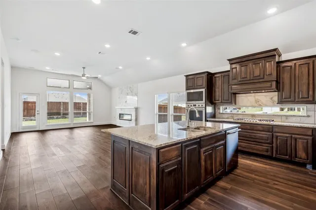 a kitchen with stainless steel appliances granite countertop a stove and a sink