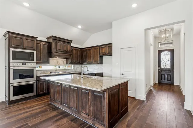 a kitchen with stainless steel appliances granite countertop a sink stove and cabinets