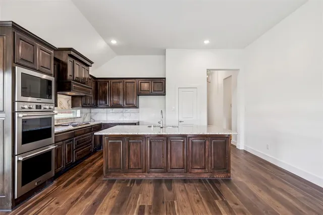 a kitchen with stainless steel appliances a stove and a sink