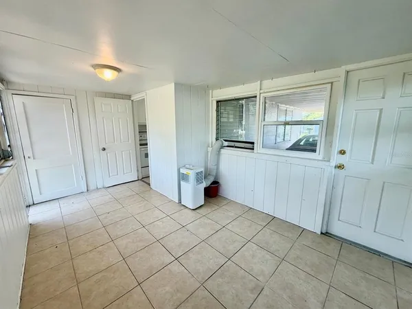 an empty room with entrance and windows