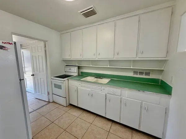 a kitchen with granite countertop white cabinets and stainless steel appliances