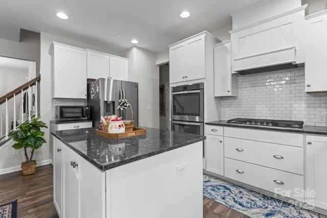 a kitchen with stainless steel appliances granite countertop a stove a refrigerator and a sink
