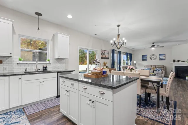a kitchen with center island wooden cabinets and a chandelier