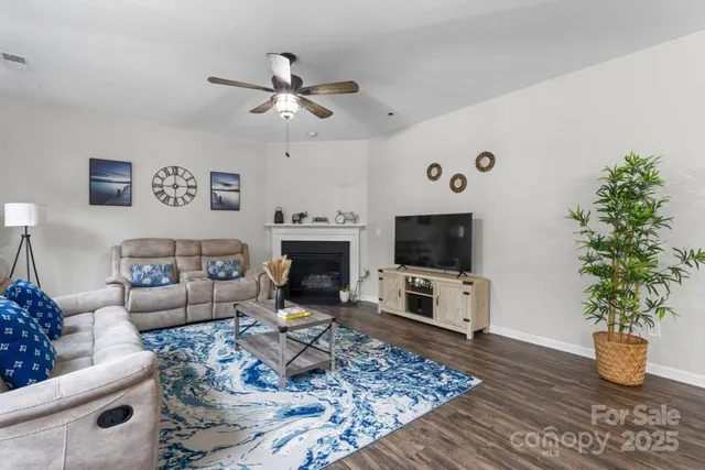 a living room with furniture a flat screen tv and a fireplace