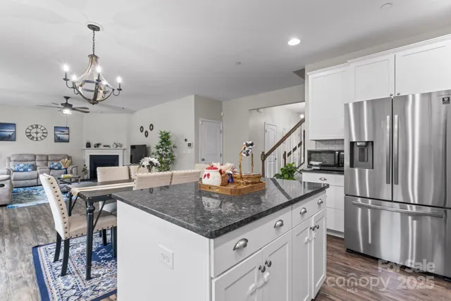 a kitchen with stainless steel appliances granite countertop a kitchen island a stove a table and chairs