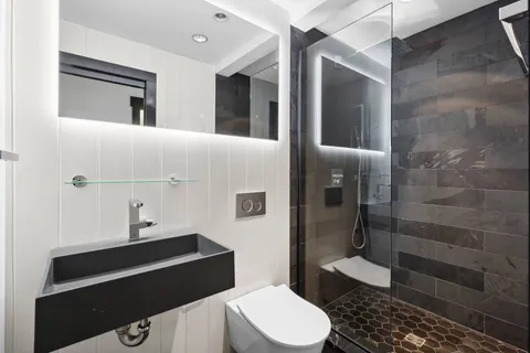 a bathroom with a sink a toilet and shower