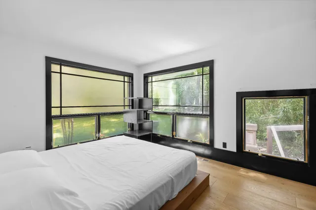 a bedroom with a bed and a large window