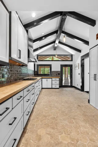 a spacious bathroom with stainless steel appliances granite countertop a sink and cabinets