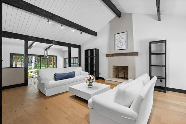 a living room with furniture fireplace and a large window